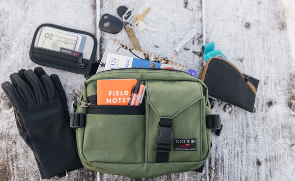 Load out showing what fits in the LPD: gloves, wallet, keys, notebook, book, pouch, small notebook, pens.